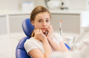 scared and terrified patient girl at dental clinic